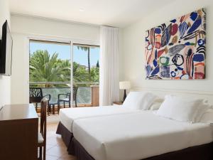 a bedroom with a bed and a large window at H10 Vintage Salou - Adults Only in Salou