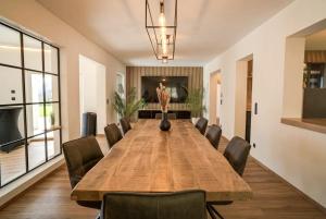 a conference room with a large wooden table and chairs at Das Freyenstein in Berghof +23 photos