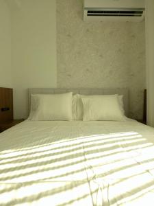 a large white bed with white sheets and pillows at Negotin Centar Boutique Residence in Negotin