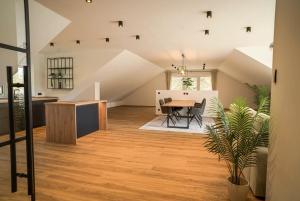 an attic kitchen and dining room with a wooden table at Das Freyenstein in Berghof