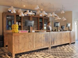 a woman standing at a wooden counter in a room at H10 Vintage Salou - Adults Only in Salou +89 photos