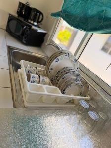 ein Kühlschrank voller Geschirr und ein Spülbecken in der Unterkunft Makeanui Lodge 2 in Rangiroa