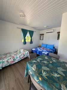 ein Zimmer mit zwei Betten und einem Tisch in der Unterkunft Makeanui Lodge 2 in Rangiroa