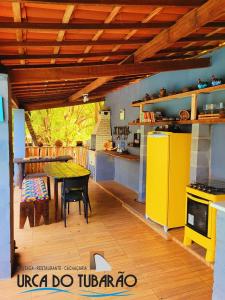 a kitchen with a table and a yellow refrigerator at Urca do Tubarão in Touros