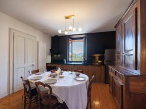 a dining room with a table and a kitchen at maison savoyarde in Doussard
