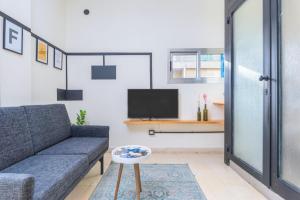 a living room with a couch and a tv at Factory Studio in Mar Mikhael in Al Mudawwar