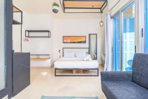 a bedroom with a bed and a couch at Factory Studio in Mar Mikhael in Al Mudawwar +6 photos