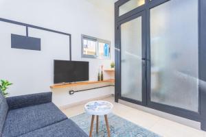 a living room with a couch and a tv at Factory Studio in Mar Mikhael in Al Mudawwar