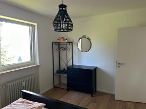 ein Schlafzimmer mit einer schwarzen Kommode und einem Spiegel in der Unterkunft Panoramapause in Wertach