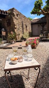 a table with wine glasses and a bowl of food on it at La Maison aux Puits in Cordes-sur-Ciel