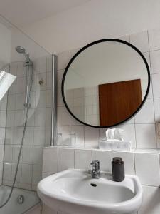 a bathroom with a sink and a mirror at Schönblick Apartments in Schönebeck
