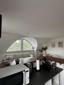 a kitchen with a couch and a microwave in a room at Schönblick Apartments in Schönebeck +6 photos