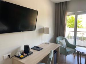 a hotel room with a desk with a tv and a chair at Hotel Fatima Center in Fátima