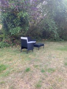 two chairs and a table in the grass at Chambre avec TV au calme in Pontgouin