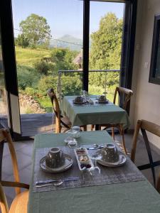 a table with plates and utensils on it with a window at Chez Mary Elise in Le Claux