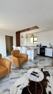 a living room with two couches and a kitchen at Yolaan Guesthouse in Sterkspruit
