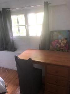 a desk in a room with a painting on the wall at Chambre avec TV au calme in Pontgouin