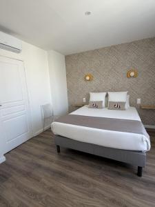 a bedroom with a large bed in a room at Hôtel The Originals Miramar, Royan Pontaillac in Royan