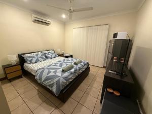 a bedroom with a bed and a television in it at Broome Rest House in Broome