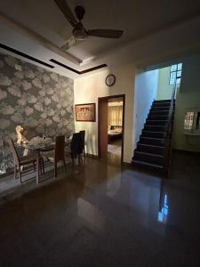 a dining room with a table and a clock on the wall at DIVINE GRACE Homestay in Udupi