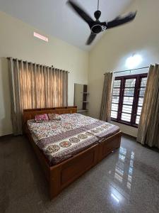 a bedroom with a bed and a ceiling fan at DIVINE GRACE Homestay in Udupi