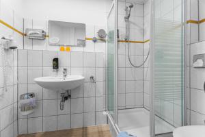 a bathroom with a shower and a sink at Hotel Norden Norddeich in Norddeich +44 photos