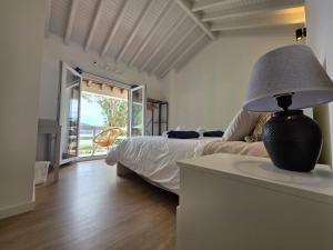 a bedroom with a bed and a table with a lamp at Varadouro Cove House in Horta