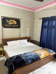 a bedroom with a bed with a blue curtain at Hotel Blue Hill in Chamba