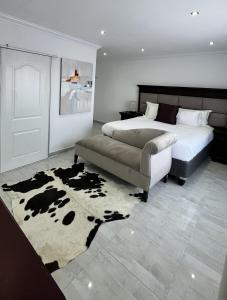 a bedroom with a bed and a cow rug at Yolaan Guesthouse in Sterkspruit