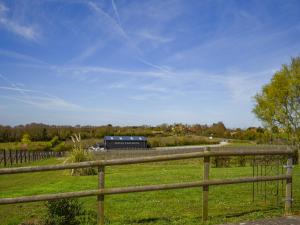 a train traveling through a field with a fence at Thistle No4 - Uk49250 in Althorne