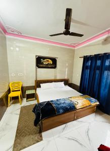 a bedroom with a bed and a ceiling fan at Hotel Blue Hill in Chamba +4 photos