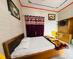 a bedroom with a bed with a red curtain at Hotel Blue Hill in Chamba