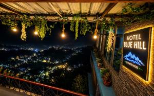 a hotel room with a view of the city at night at Hotel Blue Hill in Chamba