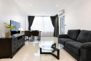 a living room with a couch and a table at The One Apartment in Rawai Beach