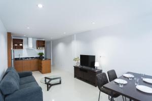 a living room with a couch and a dining room at The One Apartment in Rawai Beach