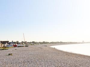 a rocky beach with boats on the shore at Thalassa in Pagham