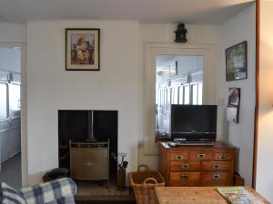a living room with a television and a fireplace at Thalassa in Pagham +8 photos