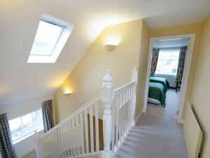 a white staircase in a home with a skylight at Pinclanty Cottage in Pinmore
