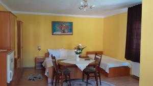 a room with a table and a bed and a dining room at Nagy Ildikó Vendégház in Lăzarea +12 photos