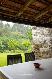 a table with two chairs and a stone wall at Quinta do Moinho in Castelo de Paiva