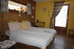 a bedroom with a bed and a window and a door at B&B Petit in Sauze dʼOulx