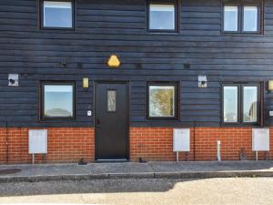 a blue building with a black door and windows at Holly No2 - Uk49254 in Althorne +1 photo