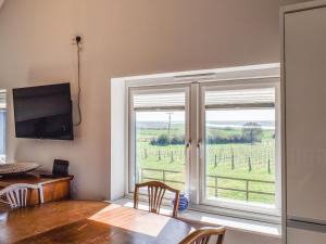 a dining room with a table and a large window at Holly No2 - Uk49254 in Althorne