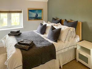 a bedroom with a large white bed with blue pillows at Holly No2 - Uk49254 in Althorne
