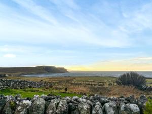 a stone fence with the ocean in the background at Bothan Aonghais in Portree