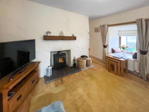 a living room with a fireplace and a television at Bothan Aonghais in Portree