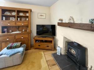a living room with a fireplace and a television at Bothan Aonghais in Portree