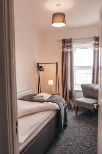 a bedroom with a bed and a chair and a window at STAYtastic in Lowestoft +8 photos