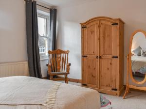 a bedroom with a bed and a dresser and a mirror at The Swiss Cottage in Pickering