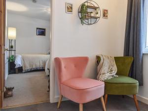 a living room with two chairs and a pink chair at The Swiss Cottage in Pickering